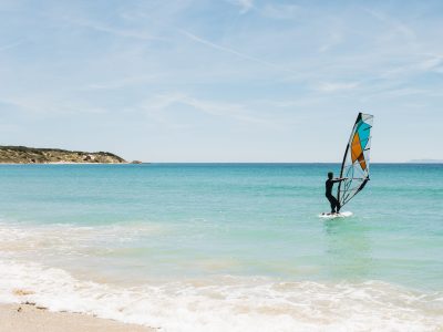 Silhouette of a windsurfer on the blue sea.
